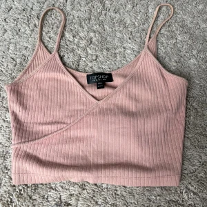Topp - Rosa crop topp från Top shop. Fint skick men lite missfärgning på banden❤️