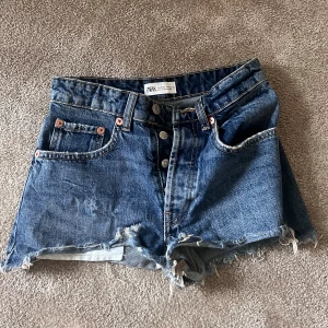 Jeansshorts Zara - Storlek 32, jättesnygga jeansshorts från zara med knapp-kedja🥰 Väldigt bra skick! Minns inte vad jag köpte dom för 😊