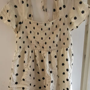 Prickig blus  - En jättesöt prickig blus med snöre som man knyter i ryggen💞 storlek L. Endast använd 1 gång så mycket fint skick💝 Perfekt till sommarn💌  