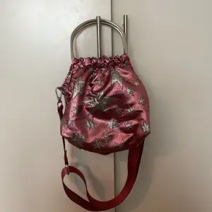 Glittrig Rosa handväska med stjärnor på från HVISK. Finns både handtag och band. Är använd men i gott skick!🩷🩷