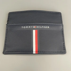 Tommy hilfiger plånbok  - Bra skick med en liten defekt se bild 3. Använd 1 år och har köpt en ny, mjukt material som sitter skönt i fickan. Pris kan diskuteras vid snabb affär 