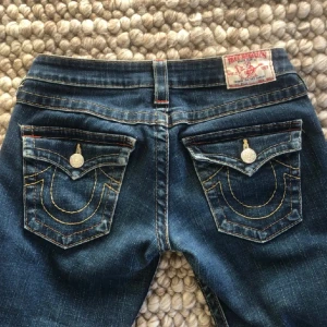 True religon jeans - Super snygga true religon jeans som är bootcut och lågmidjade. De är i storlek w27/S. Jätte bra skick, inga defekter. De är omsydda vid benen så att de ska bli mer bootcut, men syns knappt då de är samma färg. Skriv vid frågor eller fler bilder💞