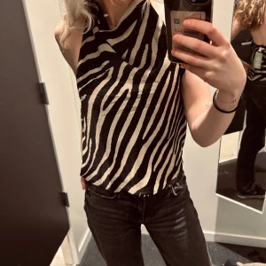 Mönstrad topp - En skit snygg trendig mönstrad topp från HM. Satin material med svarta och beig/champange ränder. Aldrig använd, Stl. S🧡 finns en liten dragkedja på sidan och ”knappar” på baksidan vid nacken.