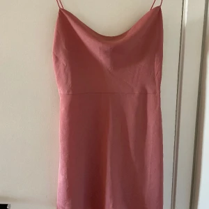 Smutsrosa miniklänning - Glansig miniklänning från Nelly. Spaghettiband. Minilängd