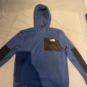 TNF HALF-ZIP HOODIE - Snygg The North Face tröja i färgen blå och lite svart. Köpt i London för 1000kr. Priset är inte hugget i sten.