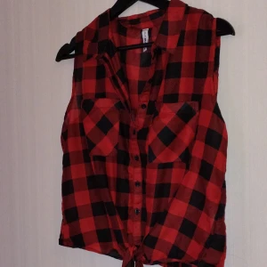 Svart rött linne  - Väldigt skönt material, går att knyta ner till om man vill. Bara testad 1 gång så den är i väldigt fint skick. 