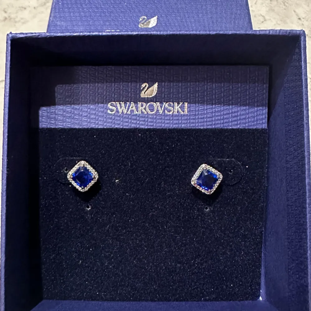 Almost new swarovski earrings, made by silver 925. Used once. Central blue swarovski crystals and small white crystals around. Perfect for an elegant outfit.. Accessoarer.