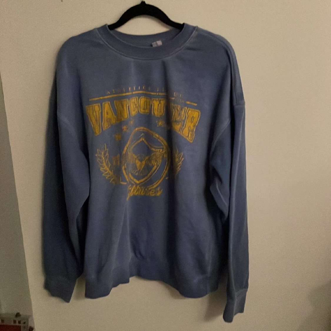 Blå sweatshirt med gult tryck. Storlek S.