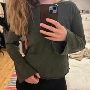 Topp - Mörkgrön långärmad topp med utsvänga ärmar 