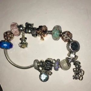Pandora armband  - Jätte fint armband som är i nyskick  15st olika Små berlocker i    Silver   Ca 20 cm och med   säkerhetskedja 
