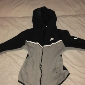 Nike tech tröja vit grå - Den är ungefär 3 månader gammal,har en liten fläck men de går bort i tvätten,storlek S