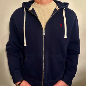 Blå Polo Ralph Lauren Zip Hoodie - 🚨KÖP 2 OLIKA PRODUKTER & FÅ 20% RABATT PÅ BÅDA 🚨En Blå Polo Ralph Lauren Fullzip Hoodie i så gott som nytt skick! Storlek M men passar även bra som S.  Modellen är 182 cm och väger 75 kg Pris öppet till förhandling!