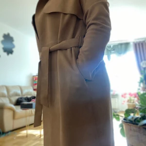 Trenchcoat mockaimitation jacka - Trendcoach mockaimitation jacka Knälång. Knytskärp i midjan.