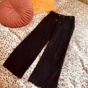  Svarta Juicy Couture byxor i nyskick - Svarta fina Juicy Couture byxor i nyskick, använt några gånger bara! Köpt på NK har kvitto. Fyllde i minsta stl här men är mindre,  8/9 står det i byxorna!