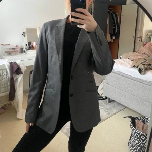 Kavaj - Säljer denna snygga gråa kavaj från hm. Denna passar från s - L beroende på hur man vill att den sak sitta 