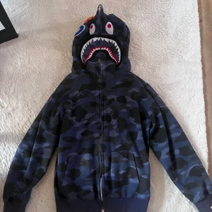 Bape Hoodie - En blå bape hoodie. Fick den i present för något år sedan och passar inte mig längre, vilket är varför jag säljer de.