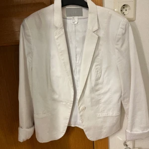 Vit kavaj  - Vit kavaj från H&M, använt 1 gång. Fint skick men smutsig nere vid kavajen men syns knappt och går bort i tvätten. Storlek 36/S säljer för 150, kom med egna prisförslag!