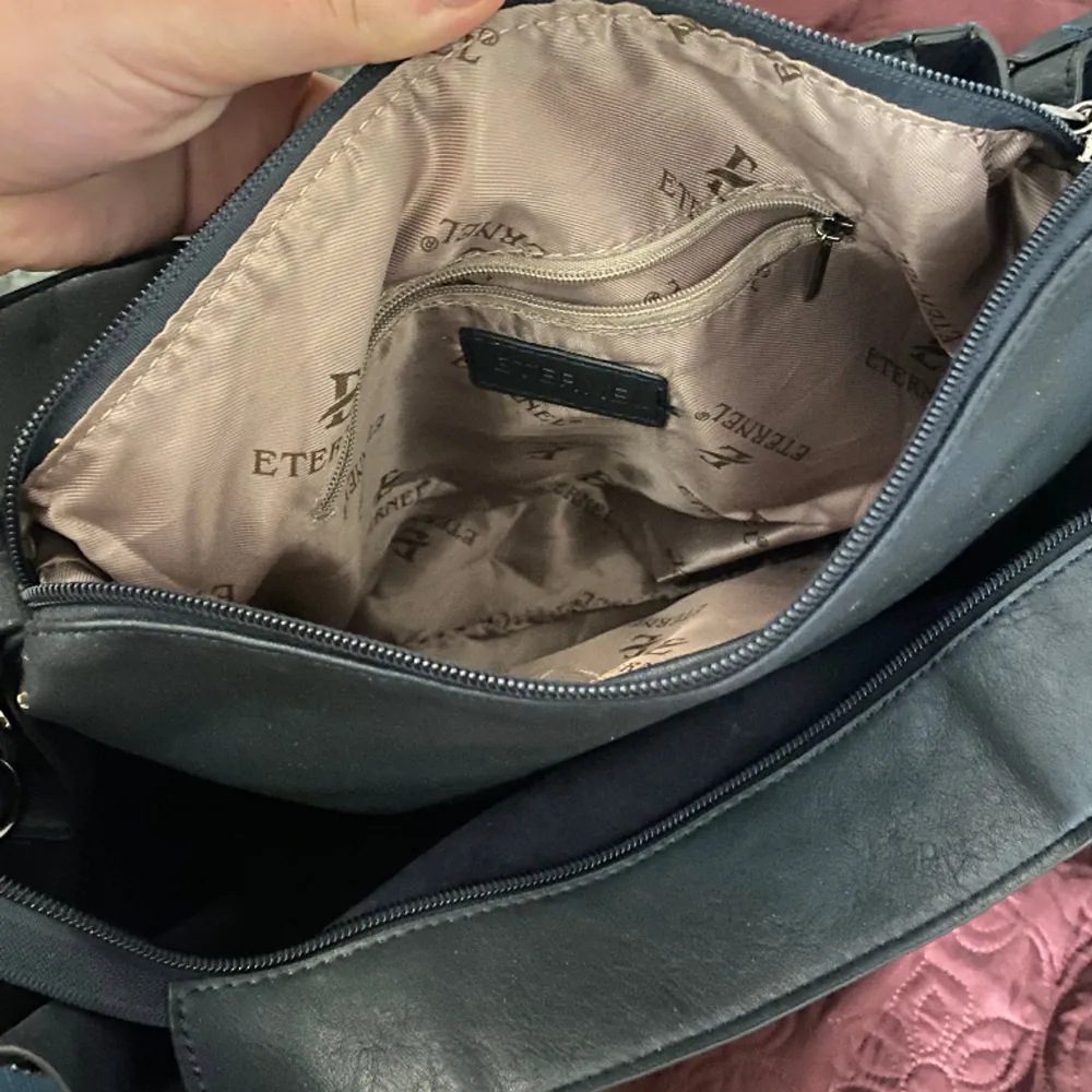 Stor rymlig väska med stenar formade som vingar, perfekt till skolan, dator och annat får plats, man kan även dra ned kedjorna både bak och fram som gör den större. . Väskor.