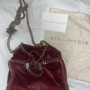Stella McCartney vöska - Säljer min älskade äkta Stella McCartney väska i modellen tiny! Tyvärr har den några defekter, men som jag tror är enkla att fixa och inget jag har stört mig på! Men därav priset! Den är vinröd med guldkedja. Säljer då jag har en liknade väska🎀❤️😋