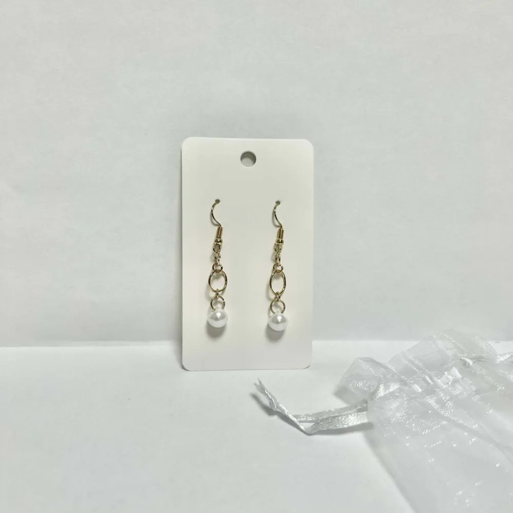 Nickelfria, handgjorda örhängen tillverkade av Smyck uf.  Långa guldiga örhängen med pärla (oanvända) . Accessoarer.