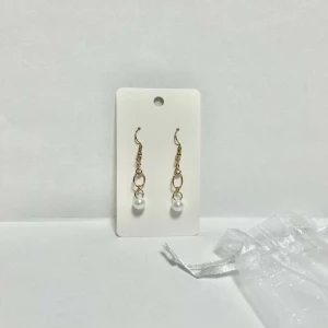 Örhängen  - Nickelfria, handgjorda örhängen tillverkade av Smyck uf.  Långa guldiga örhängen med pärla (oanvända) 