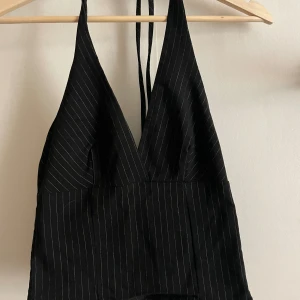 Topp NA-KD - ”Kostym”-topp från NAKD i storlek 34. Använd endast fåtal gånger då den är lite för liten för mig. Materialet är mjukt och stretchigt! Den har dragkedja på sidan och knyte runt halsen.