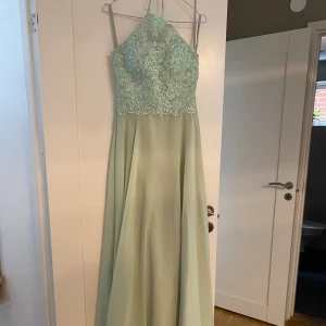 Ljus grön balklänning säljes! 💚  - Mycket bra skick. Överdelen är lite mönstrad med paljetter och själva kjolen har en lite slits🤩 Aldrig använd (köpte en annan). Jag är 165 ish och den går långt ner förbi fötterna. Nypris: 1 240kr. Hör av er om ni har några funderingar!