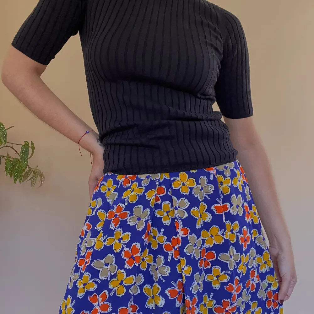 Vintage Purple Floral Printed Skirt w frontal pleating. Side Button and Zip Closure. Some color transfer in a white area, not visible when worn. Very Good Condition. Unlined. Best Fits M  Model is 160cm (5”3) and generally fits XS/S.  100% Silk. Kjolar.