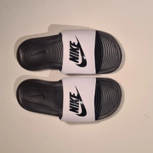 Nike slides - Ett par nike victori one slides. Säljer dessa då de är för små för mig. Väldigt bra skick och knappt använda då de är för små för mig. Nypris på dessa är 379kr på zalando.