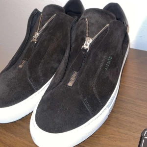 Zip Axel Arigato skor - Säljer mina zip axel arigato skor som är i mocka . Använt 3 ggr då dom är för små för mig. Pris kan disskuteras.  Skick på skorna 10/10 ser helt oanvändna ut.