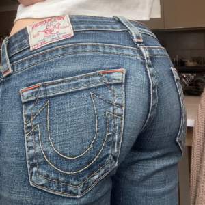 Skitsnygga och lågmidjade True Religion jeans i superfint skick. Dem är mer raka än bootcut 💓Skriv vid funderingar/prisförslag!! Midjemått: 37cm ca  Ytterbensmått: 100cm Innerben: 82cm. Några få slitningar vid benen, därav är priset diskuterbart