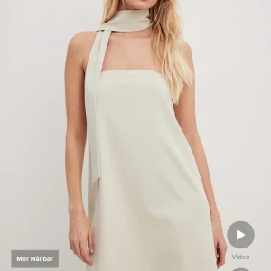 Tube klänning med scarf - Snygg ljusbeige tube klänning från NA-KD. Aldrig använd, lite skrynklig från paketet. Storlek 36. Ser kortare ut på bilden men är i en bra längd 