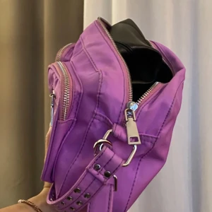 Lila Noella väska 😍😍 - Lila/rosa  väska från noella i vattentåligt material. Det finns både ett lång och ett kort band. 💜💗