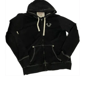 True religion hoodie - True religion hoodie white stitching, en fläck på armen som är typ 5mm liten så syns inte. Skriv innan ni köper, och pris kan såklart ändras.