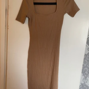 Karamellfärgad stickad miniklänning  - Karamellfärgad midiklänning som är stretchig