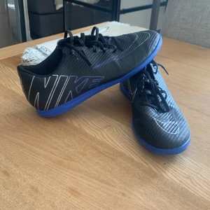 Innomhus skor strl 42 - Nike Mercurial Vapor 15 Club IC Shadow - Svart/Krom/Blå Skor i bra skick, använda under mindre än 1 vintersäsong. Säljs då jag inte har behov av skorna längre.