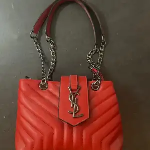 En helt ny och oanvänd röd Yves saint Laurent väska, säljer den på grund utav att det inte är min stil längre.