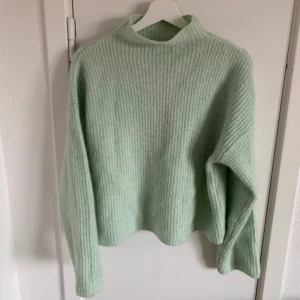 Stickad tröja  - Mintgrön stickad tröja med hög krage. Längd normal. Använd fåtal gånger 