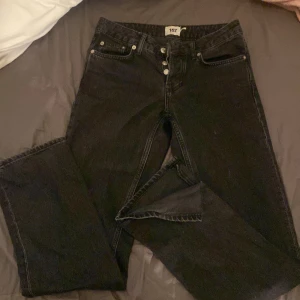 Svarta jeans  - Svarta mid jeans.är inte så små i midjan och har slits längst ner.