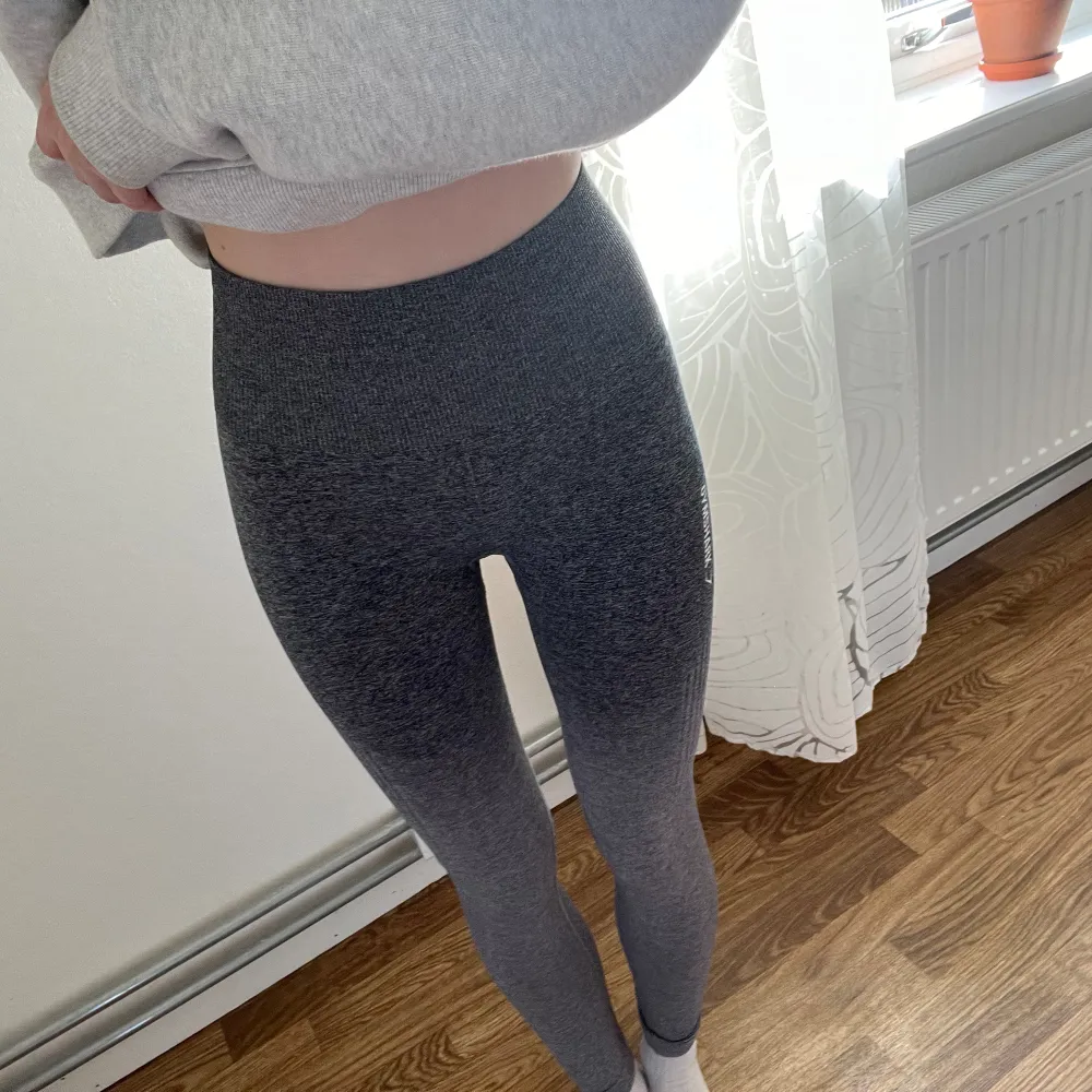 Gråa ombre tights från Gymshark som är från en äldre kollektion. Bra skick men märker vid benslutet är utsuddat och kanske någon/några sprickor på märket vid låret. . Farkut & Housut.