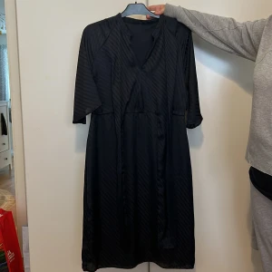 Klänning - Den är marinblå och knappast använd, längden är ned till knäna 