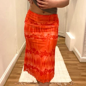 Orange Sommarkjol  - Supersöt orange lång sommarkjol med hawaii blommor i storlek XS. Slutar precis under knäna på mig som är 162 cm 🧡