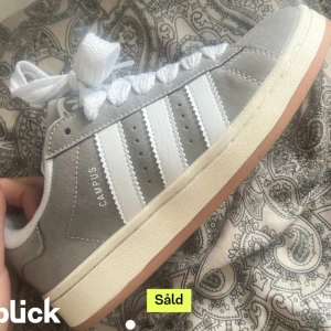 ADIDAS CAMPUS GRÅA - Säljer dessa supercoola eftertraktade adidas campus 00s!😍💋 De är typ helt nya och har inga defekter eller andra tecken. Säljer då jag köpta dem av en annan säljare men de passade inte. Storlek 37 1/3. Skriv vid fler frågor. ANVÄND GÄRNA KÖP NU!