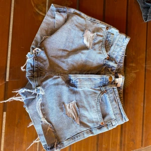 Jeansshorts - Säljer ett par jeansshorts från hm som är använda en sommar i strl 34 i midwaist. Säljer då de tyvärr har blivit försmå för mig 