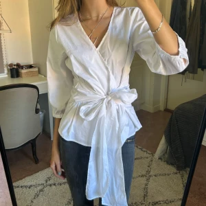 Topp - Säljer denna vita blus som kan knytas på flera olika sätt. Sparsamt använd så i väldigt bra skick!💕