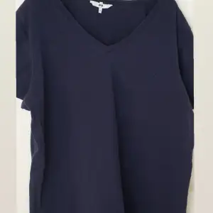Marinblå T-shirt med liten V-ringning. Andvänd fåtal gånger. 
