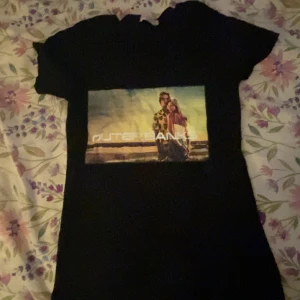 Outerbanks t-shirt - Säljer nu en intressan oanvänd outerbanks t-shirt som är en bild från två huvudpersoner i serien! Storlek L men uppskattad M