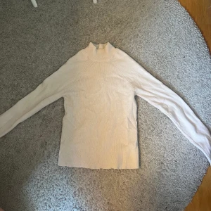 Slimmad stickad tröja  - Fin stickad tröja som sitter slimmat på kroppen! Bra skick, förutom lite trådar längst ner!