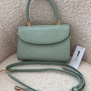 Helt ny söt liten väska  - Helt ny söt liten väska som även går att använda som axelremsväska. 