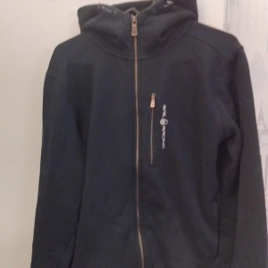 Sail Racing zip hoodie - En riktigt snygg och väldigt bekväm hoodie i mörk blå som passar till väldigt mycket. Säljer den eftersom jag valt att byta stil. Den är i väldigt bra skick och har inga hål eller andra skador. Ny pris: 1500 Pris går absolut att diskutera.